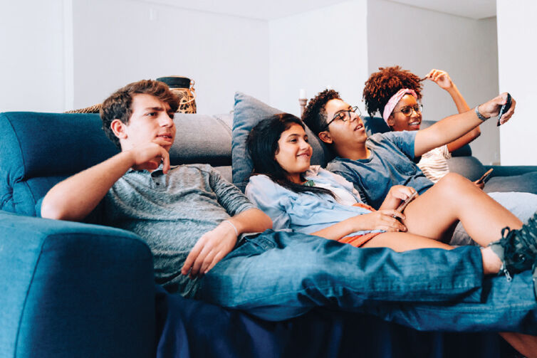 Group of teenagers on a couch, channel-surfing
